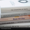 Set of decorative books for display. Real hardcover books in white, blush, and silver purple used for decorating. Decorative cookbook, cocktail book, and coffee table book.