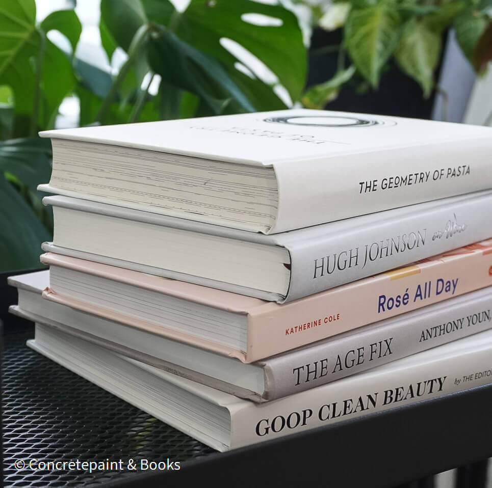 Set of decorative books for display. Real hardcover books in white, blush, and silver purple used for decorating. Decorative cookbook, cocktail book, and coffee table book.