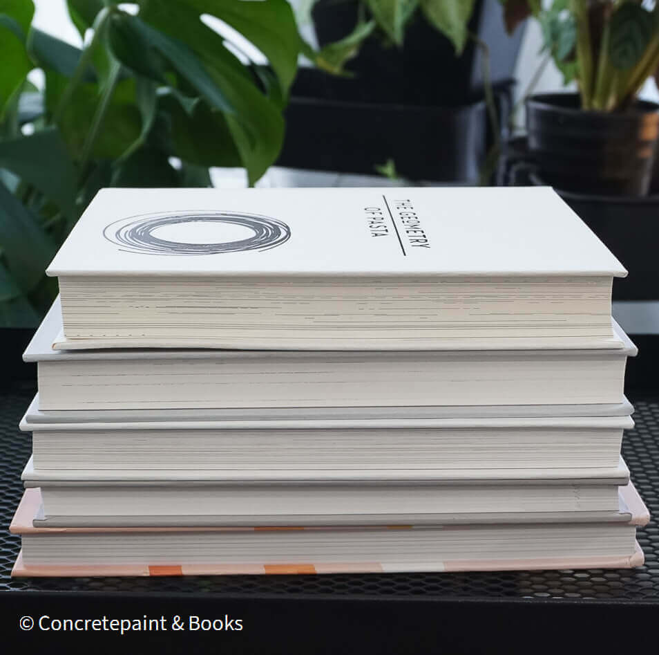 Set of decorative books for display. Real hardcover books in white, blush, and silver purple used for decorating. Decorative cookbook, cocktail book, and coffee table book.