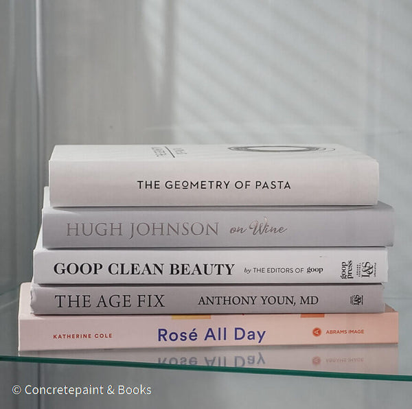 Set of decorative books for display. Real hardcover books in white, blush, and silver purple used for decorating. Decorative cookbook, cocktail book, and coffee table book.