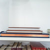 Stack of hardcover books in navy blue and neutral colors. Real books staged and used for decorating.