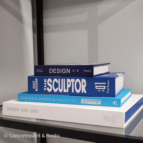 Stack of white and blue hardcover coffee table books. 