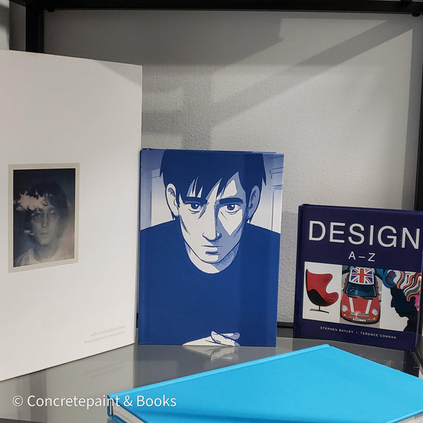 Stack of white and blue hardcover coffee table books. 