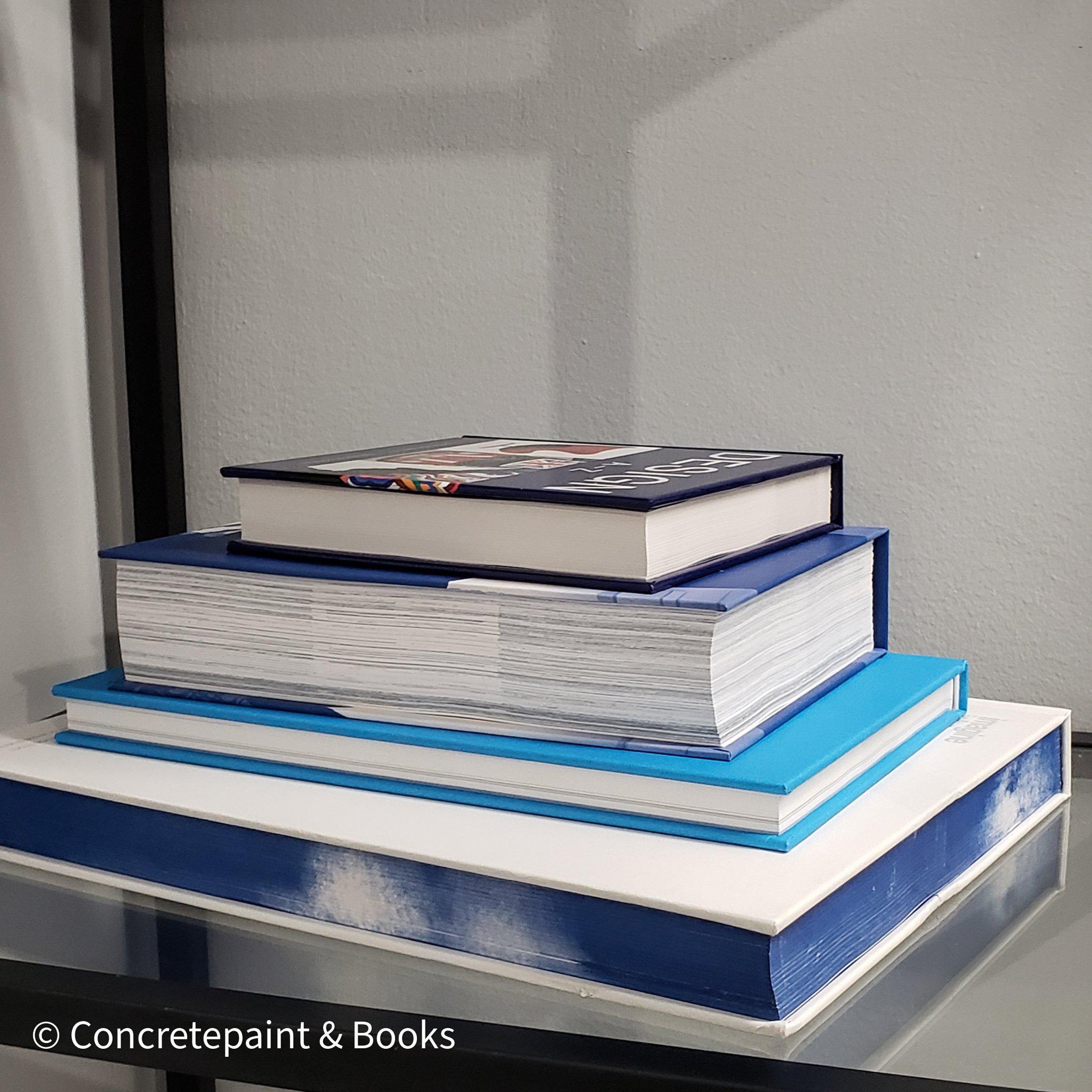 Stack of white and blue hardcover coffee table books. 