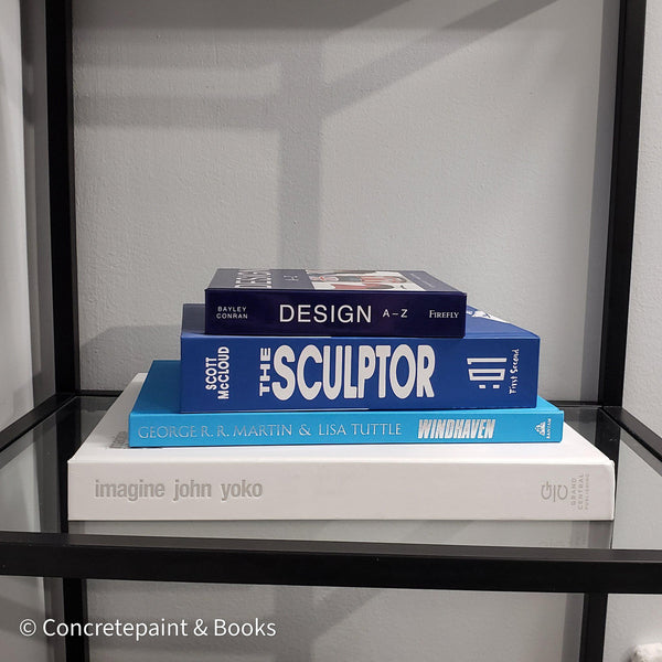 Stack of white and blue hardcover coffee table books. 