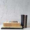 Real black and neutral headcover books used as staged home décor. Novels and large coffee table books black and neutral.