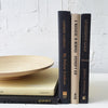 Real black and neutral headcover books used as staged home décor. Large coffee table books black and neutral with ikea bamboo bowl on top.