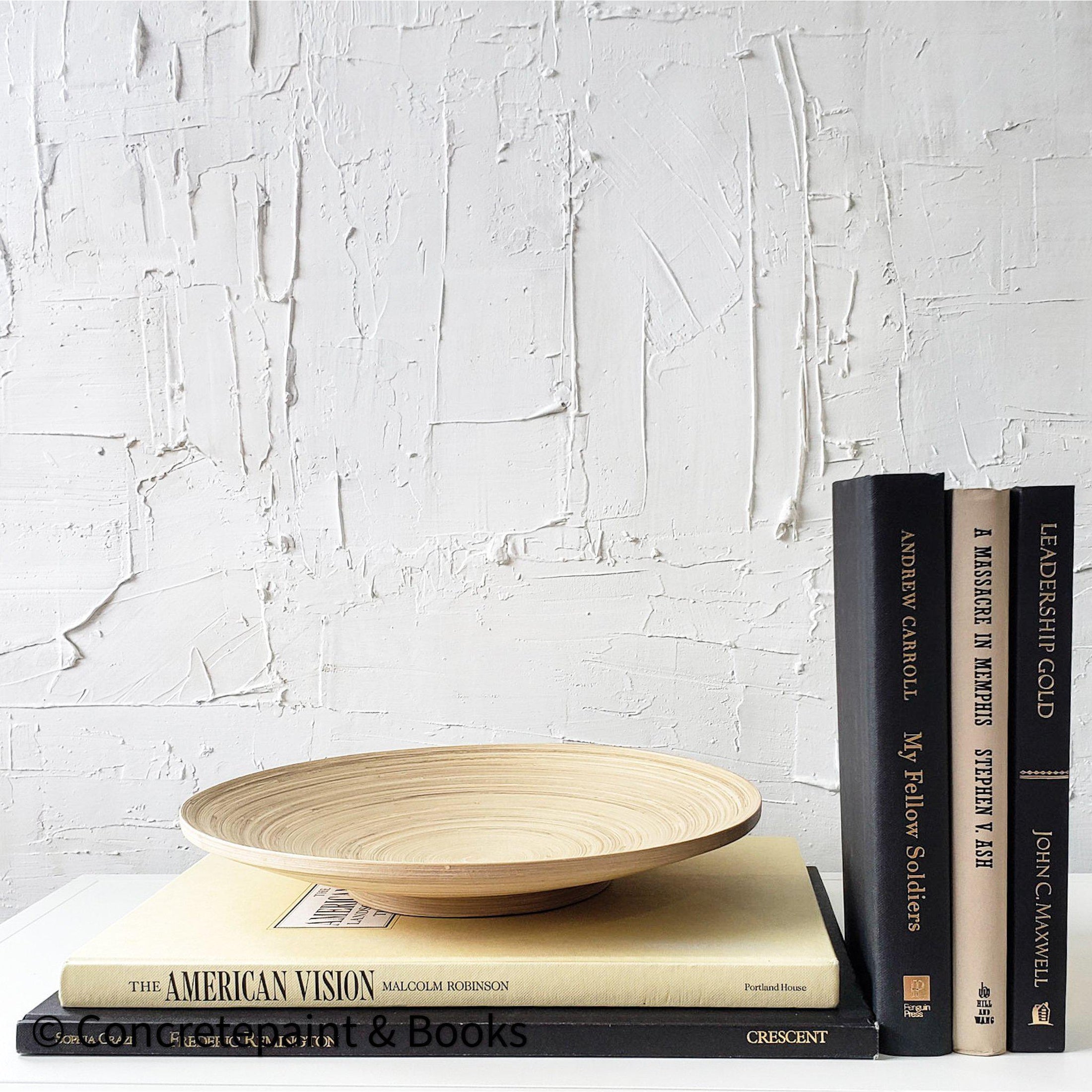 Real black and neutral headcover books used as staged home décor. Large coffee table books black and neutral with ikea bamboo bowl on top.